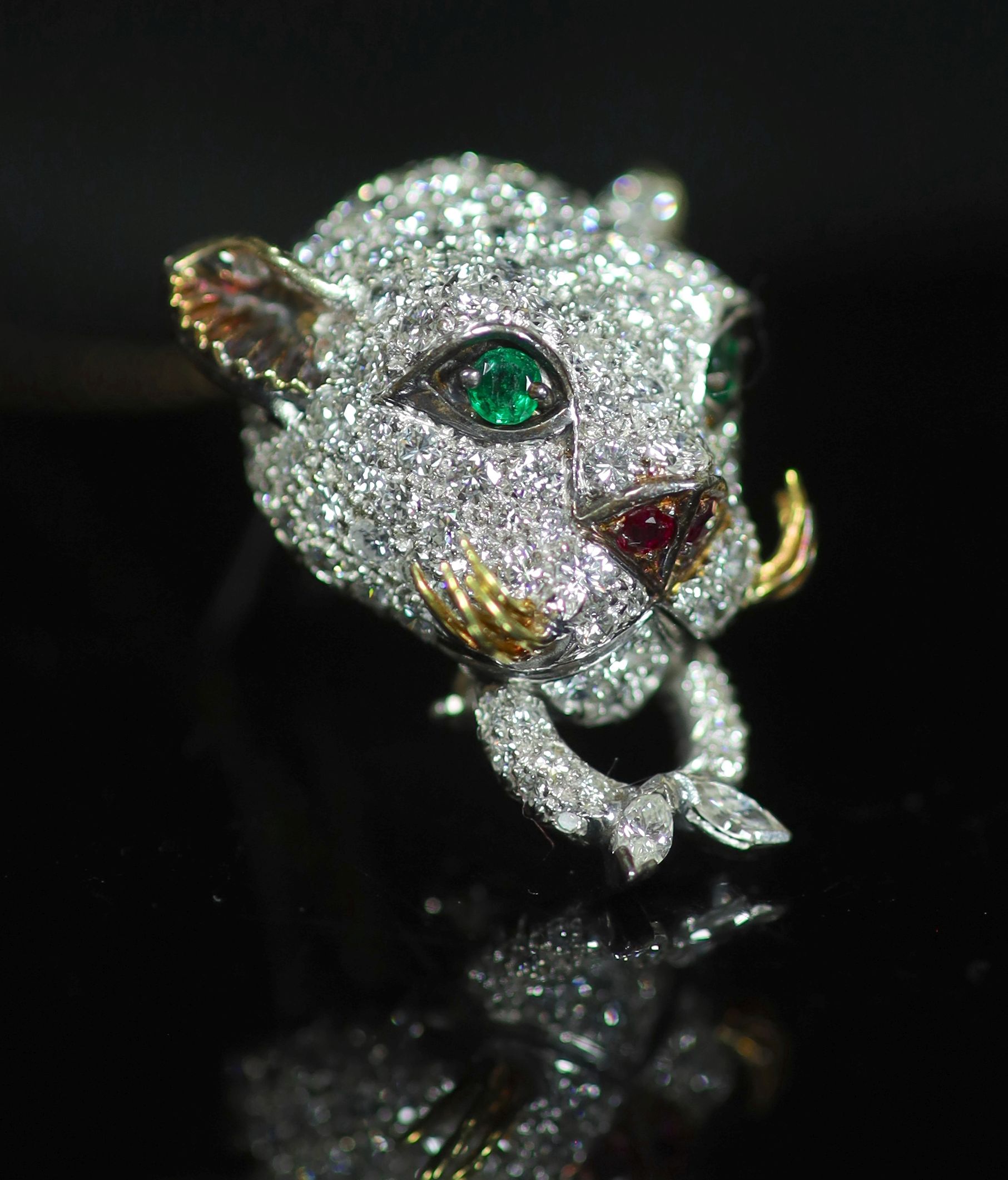 An 18K white gold and diamond leopard's head clip brooch, with emerald eyes, ruby nose and gold whiskers,